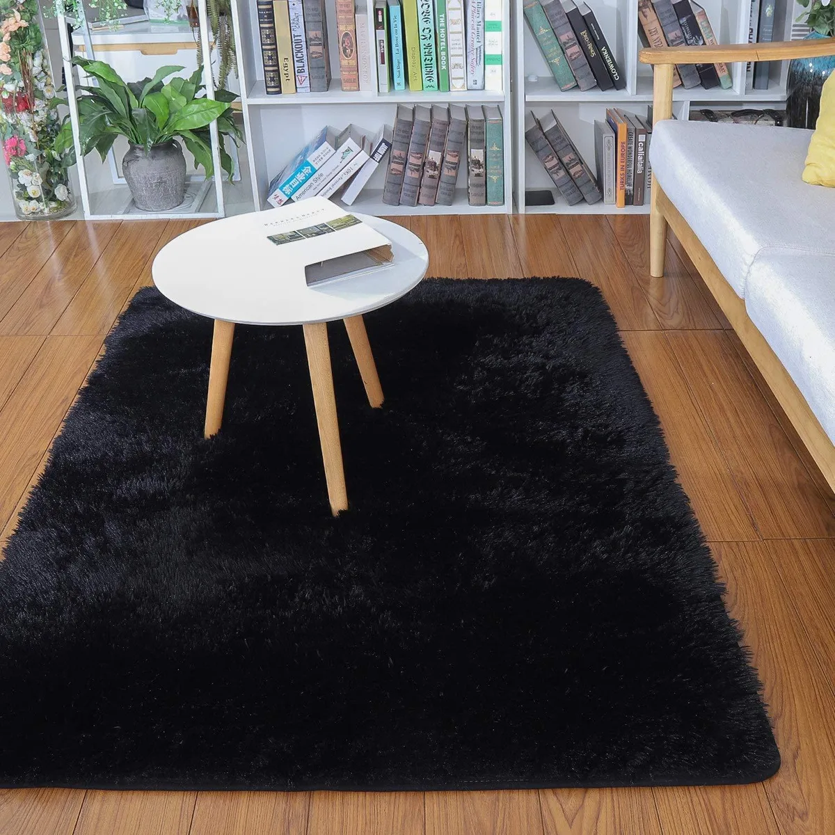 Black rectangular velvet area rug with plush shaggy pile, 2 by 3 feet