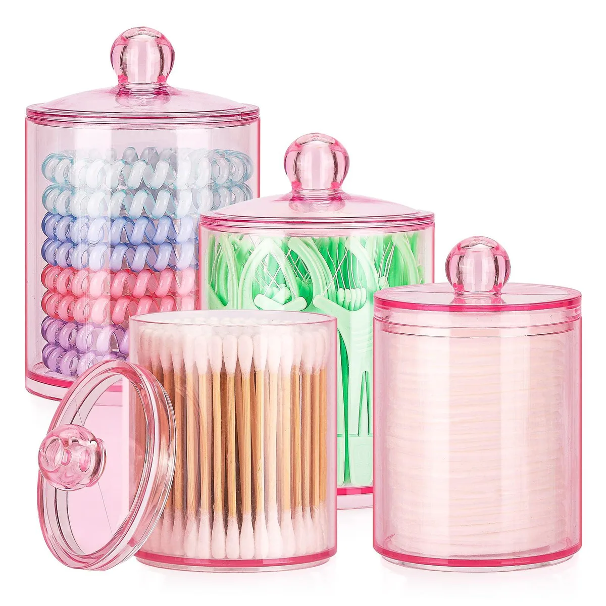 Four pink plastic apothecary jars with lids, two 12 oz and two 10 oz, sitting together