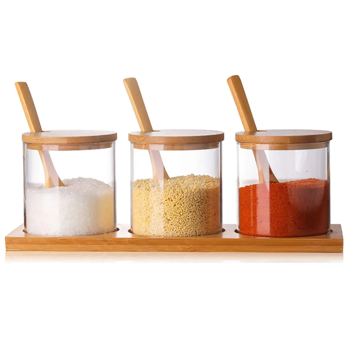 Three clear glass jars with bamboo lids spoons and tray