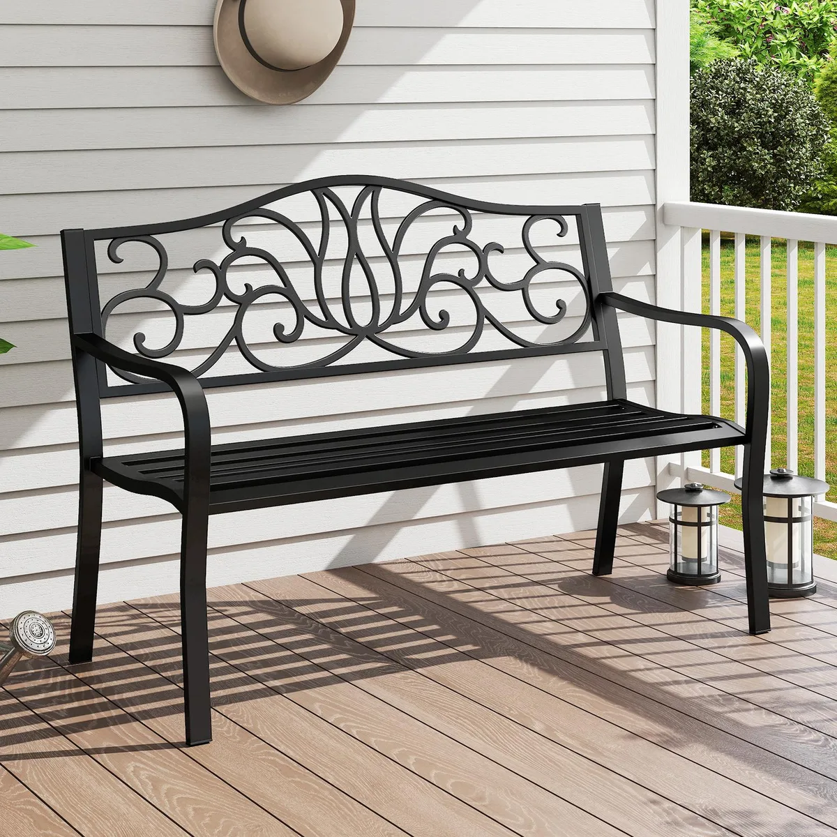 A 50 inch black and grey metal garden bench with a floral scroll backrest and slatted seat