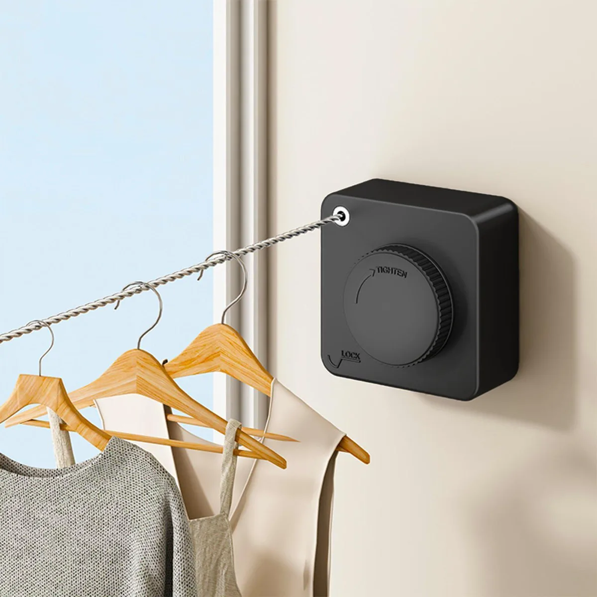 Black retractable clothesline unit with pull-out line and wall hook, compact plastic housing