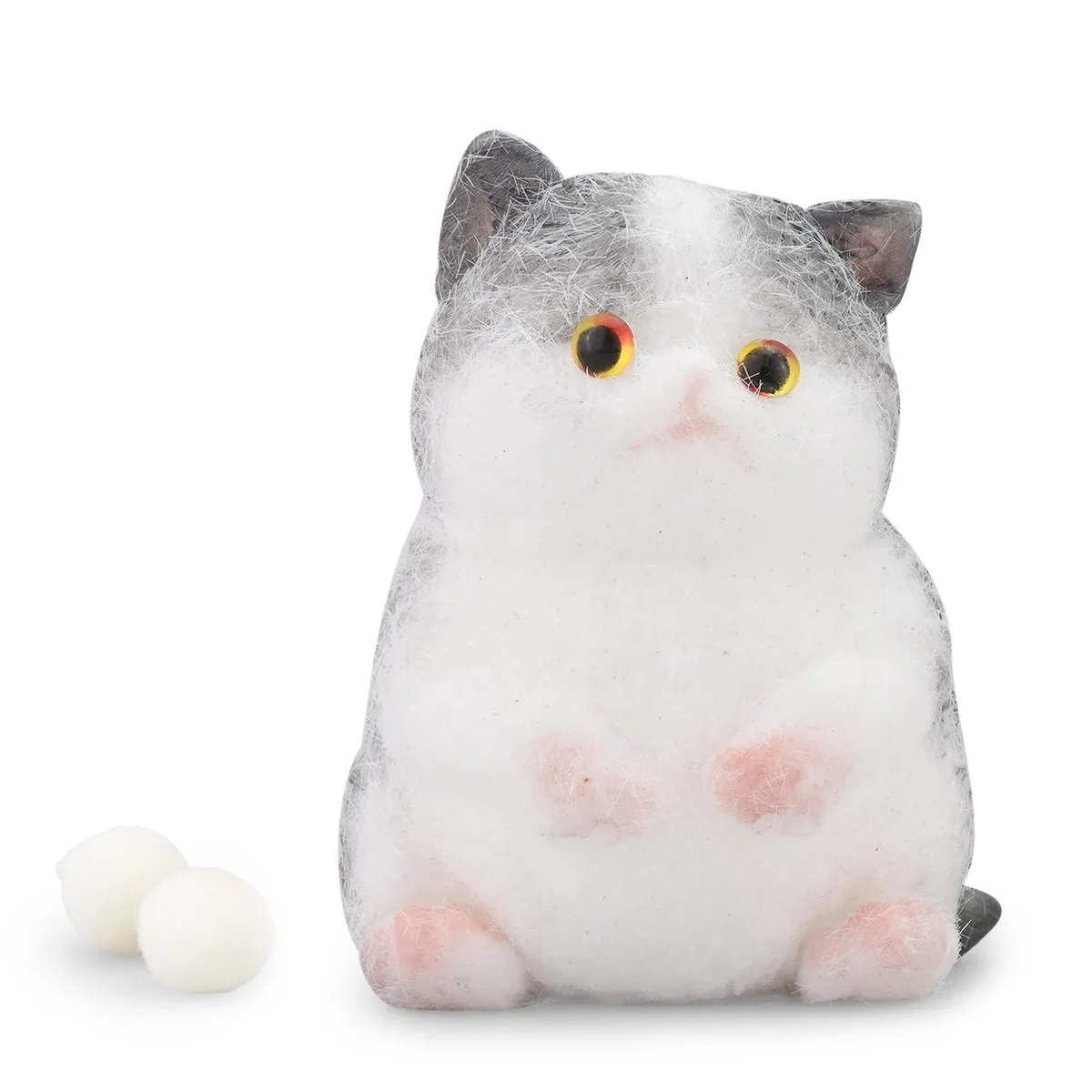 A soft pink cat-paw squishy toy inside a clear sealed bag with tiny loose beads