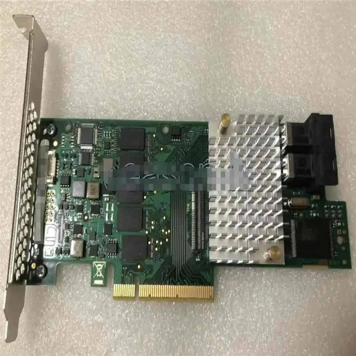Green printed circuit board RAID controller card with silver PCIe connector and black heatsink