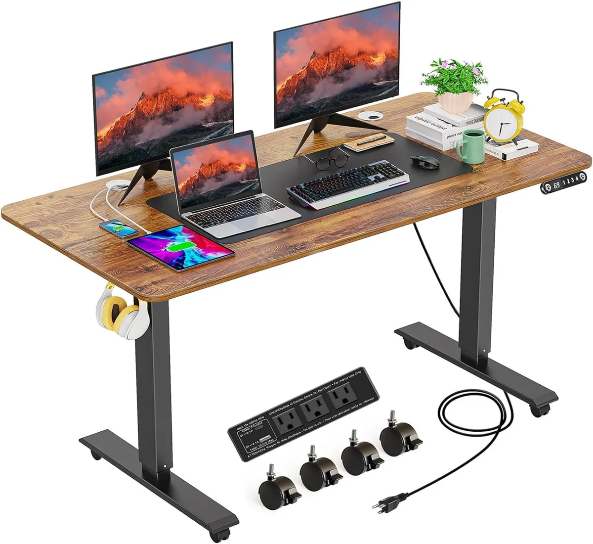 Brown rectangular standing desk with metal frame, built-in power outlets, USB ports, caster wheels and a large mouse pad