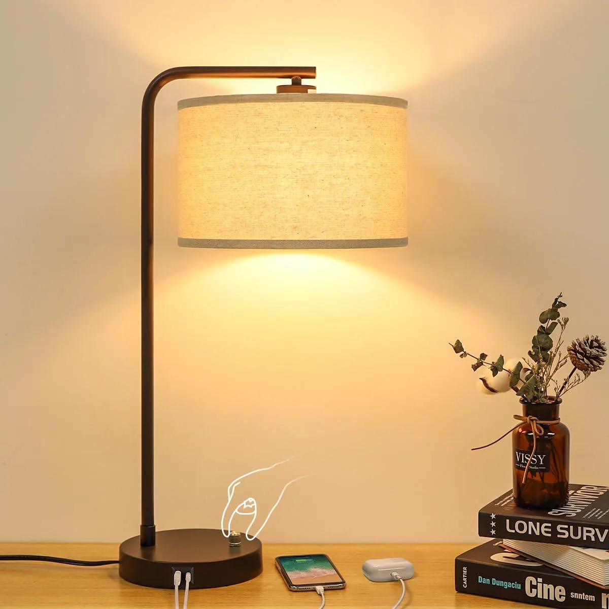 A 25 inch tall table lamp with a round linen shade and coated metal base, USB C and A ports on the side