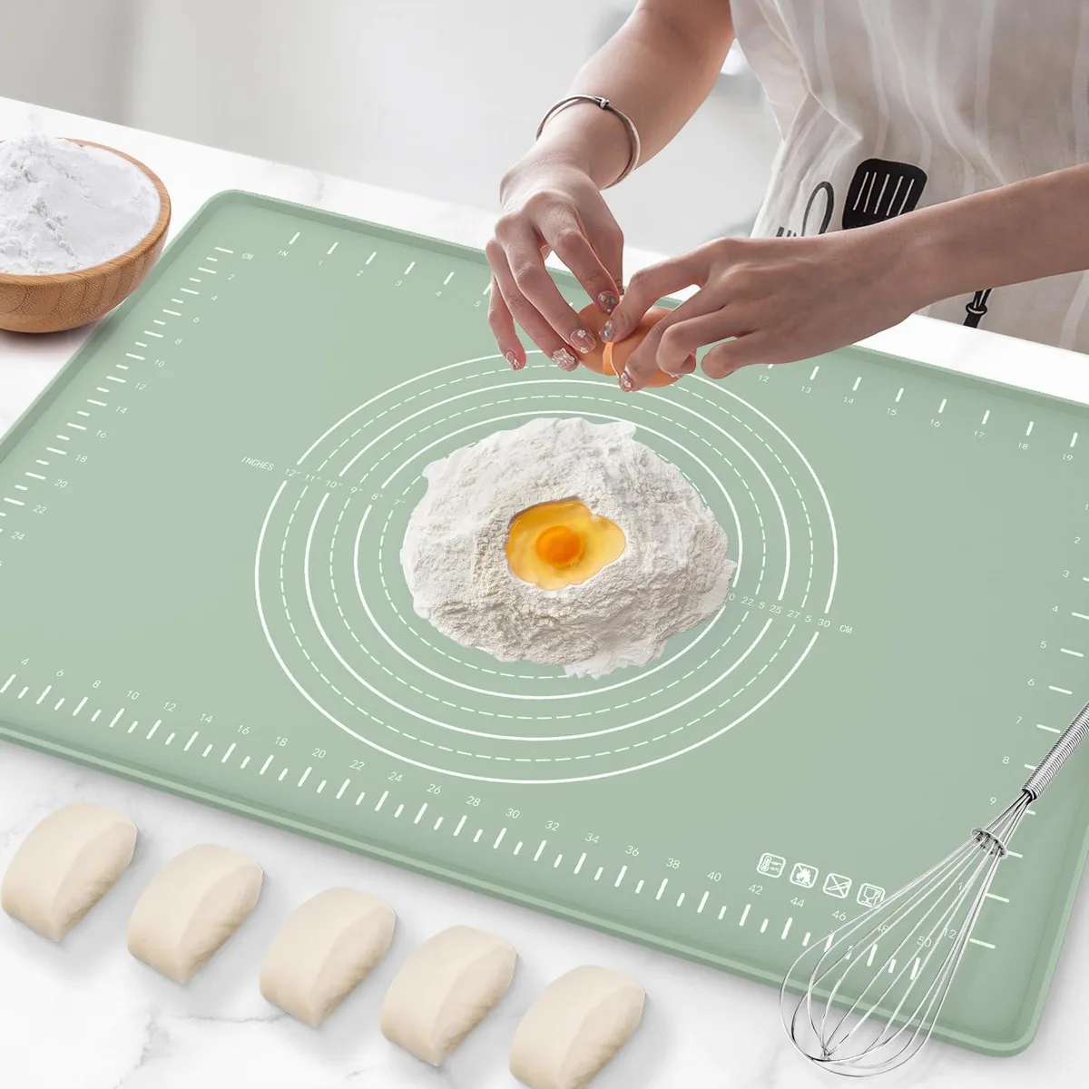 Green rectangular silicone baking mat with raised edges and printed measurement markings