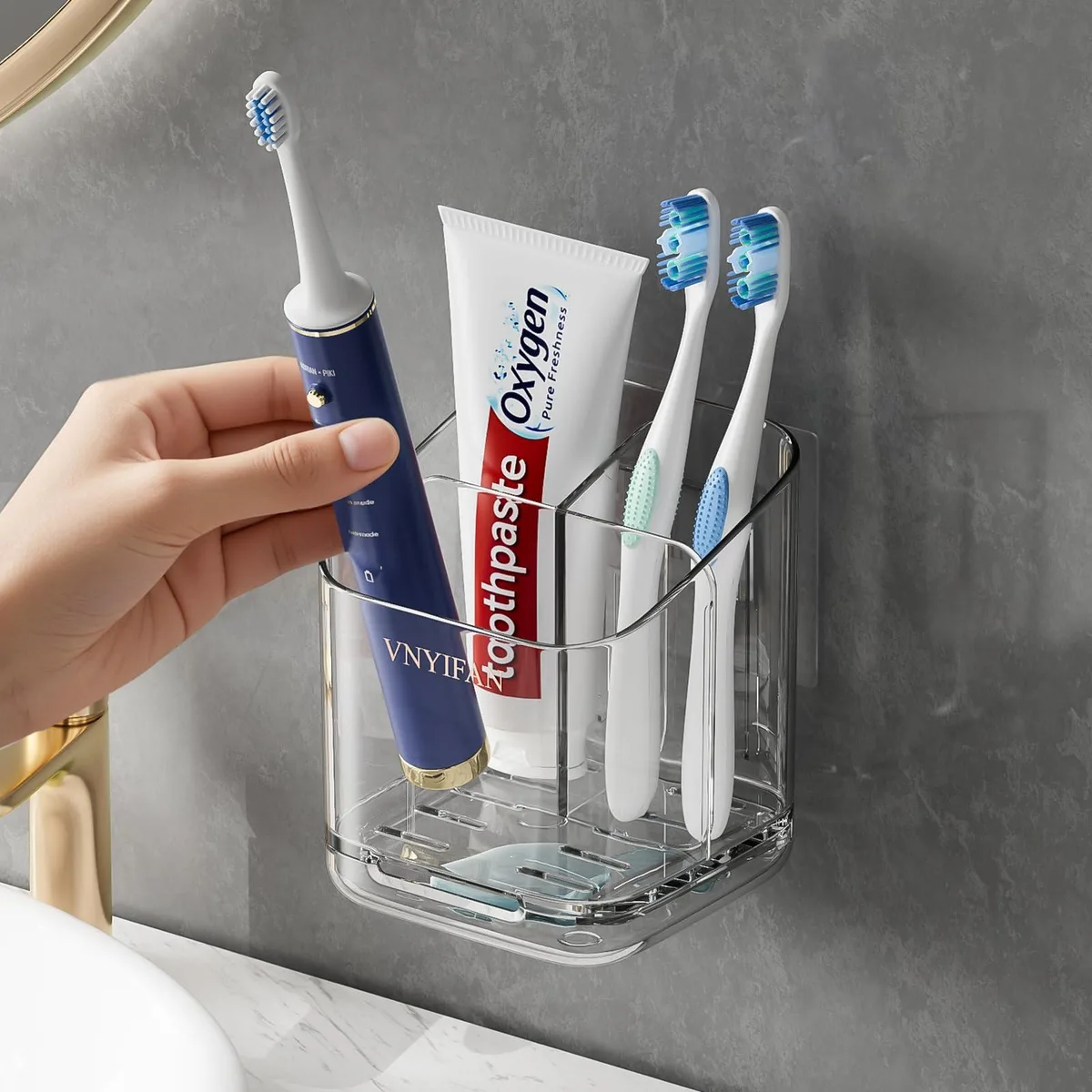 Clear plastic wall-mounted toothbrush holder with three divided slots and removable drip tray