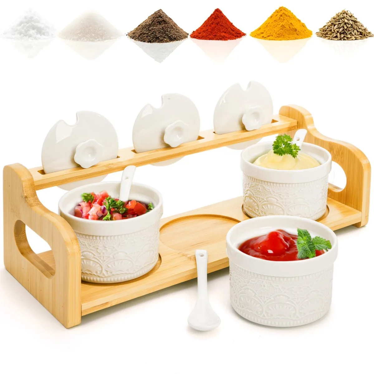 Three red ceramic jars with lids and spoons on a bamboo tray with cutout handles