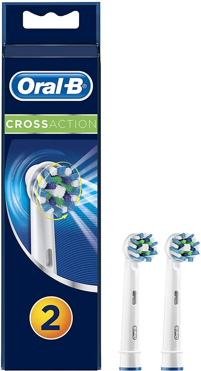 Two white round brush heads with soft angled bristles and green indicator tips