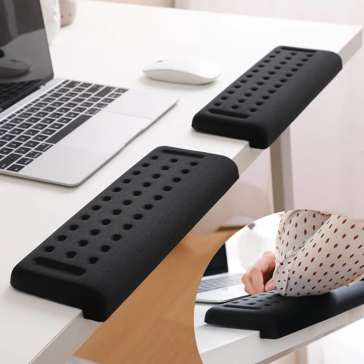 Two L-shaped leather wrist rests on a desk edge
