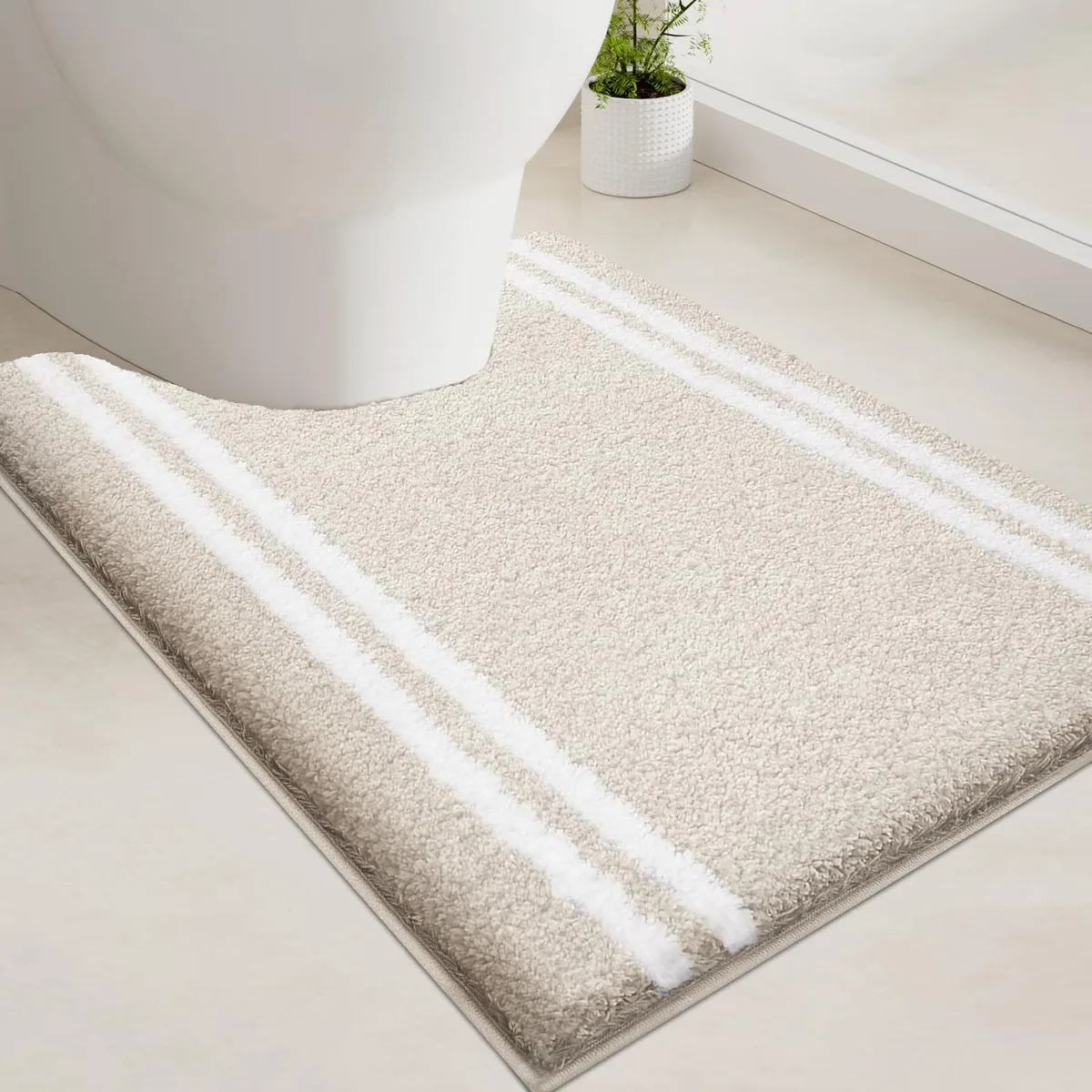 Beige U-shaped bath mat with plush shaggy surface and non-slip backing