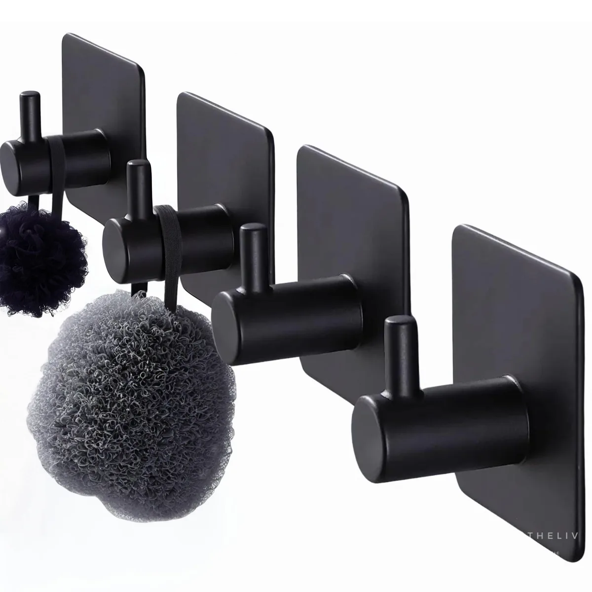Four black adhesive wall hooks on a plain surface