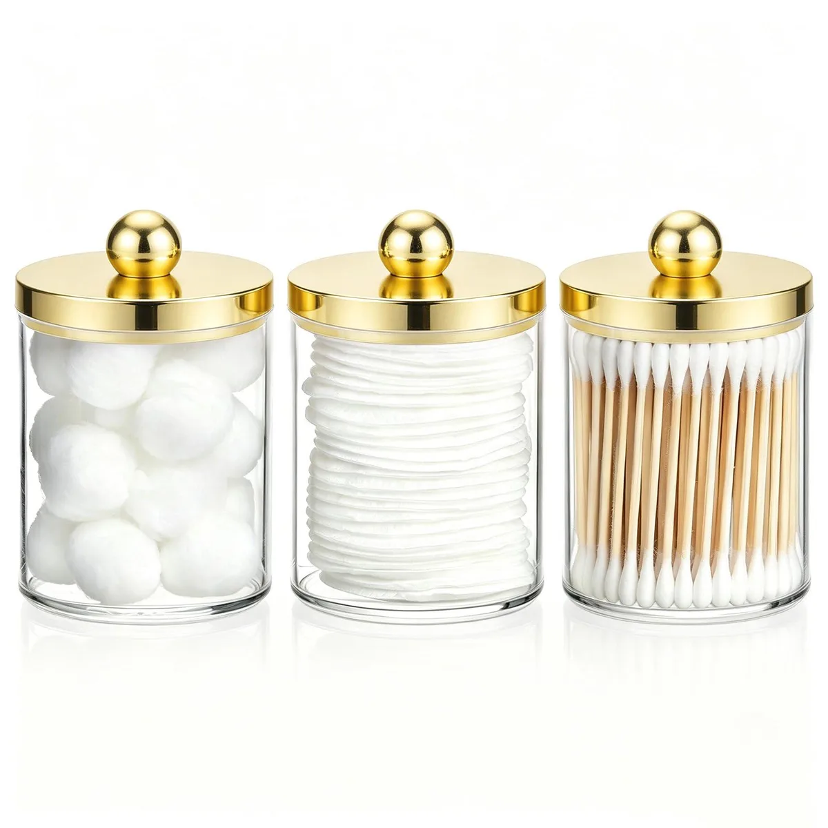 Three gold-lidded plastic apothecary jars on a surface