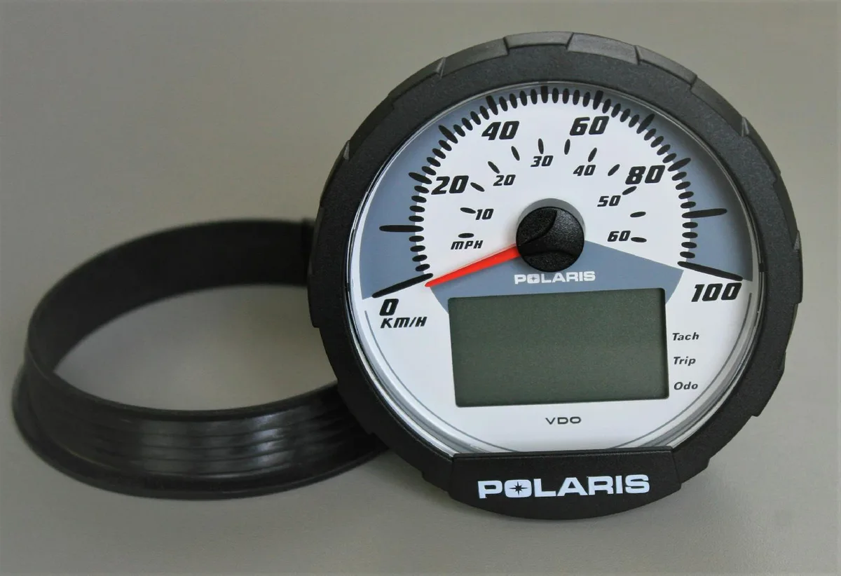 Black rectangular speedometer cluster with white dial marked 60 MPH and 100 KMH, Polaris branding, connector on back