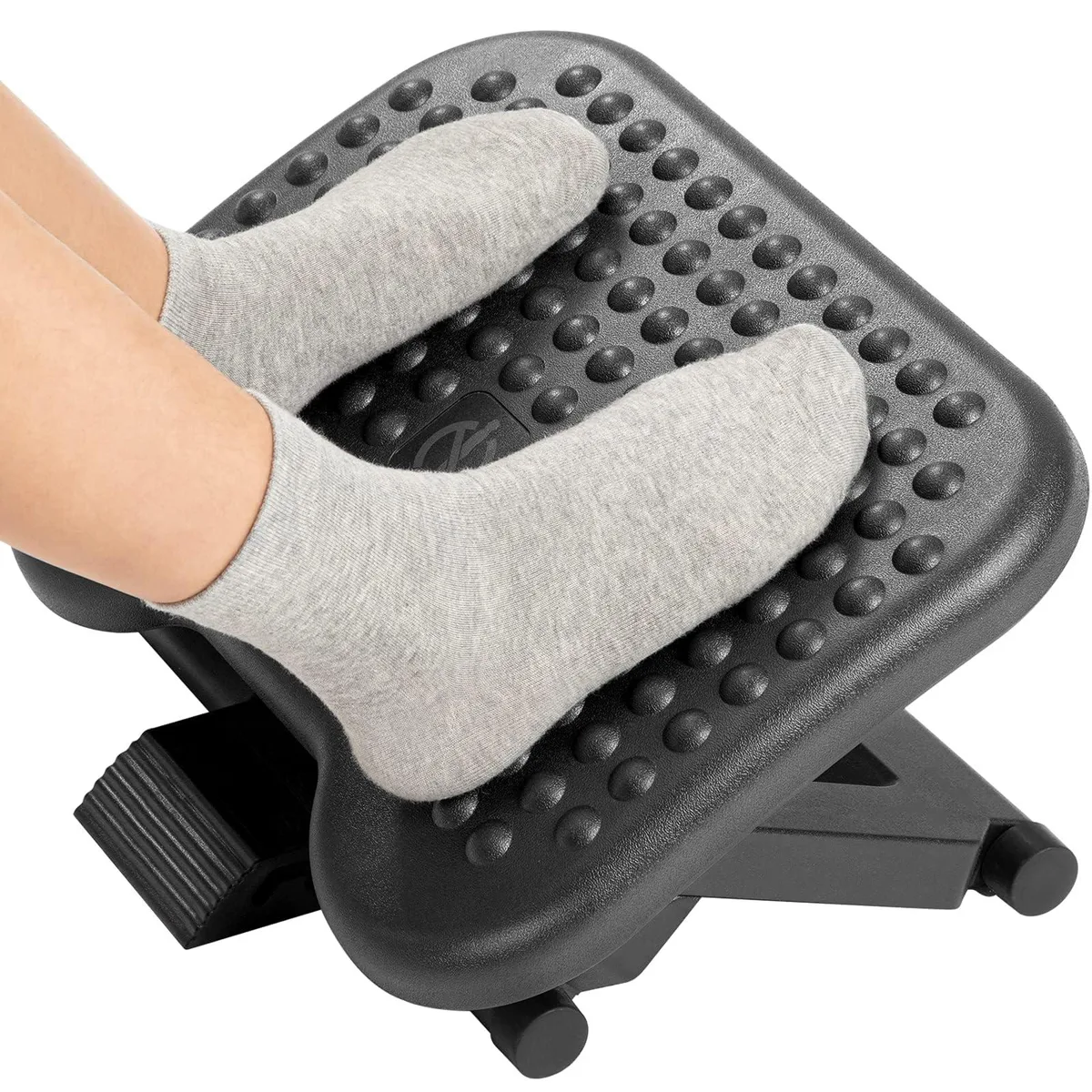 Black plastic footrest with textured circular surface and adjustable height legs