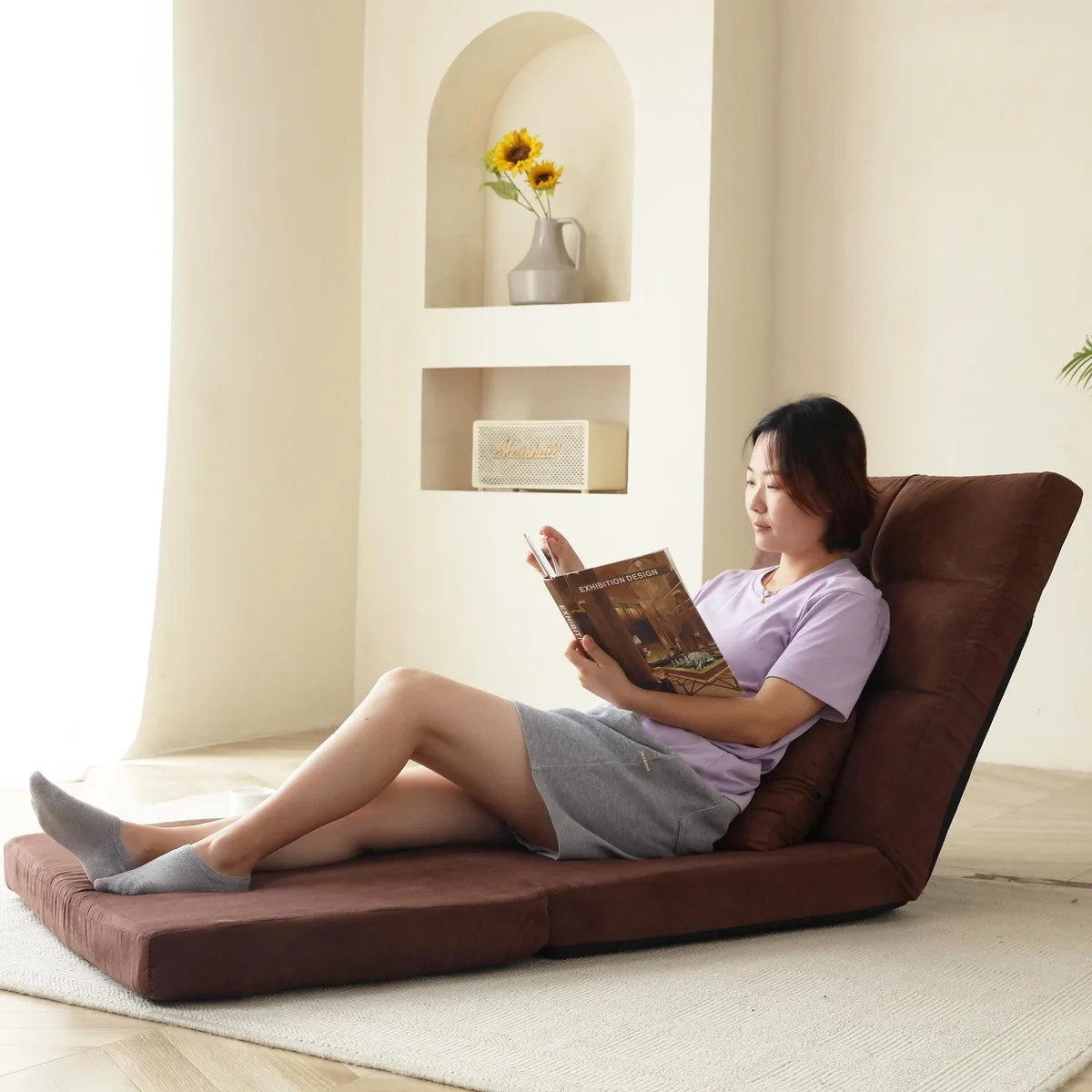 Brown triple-fold sofa bed with metal frame and one throw pillow