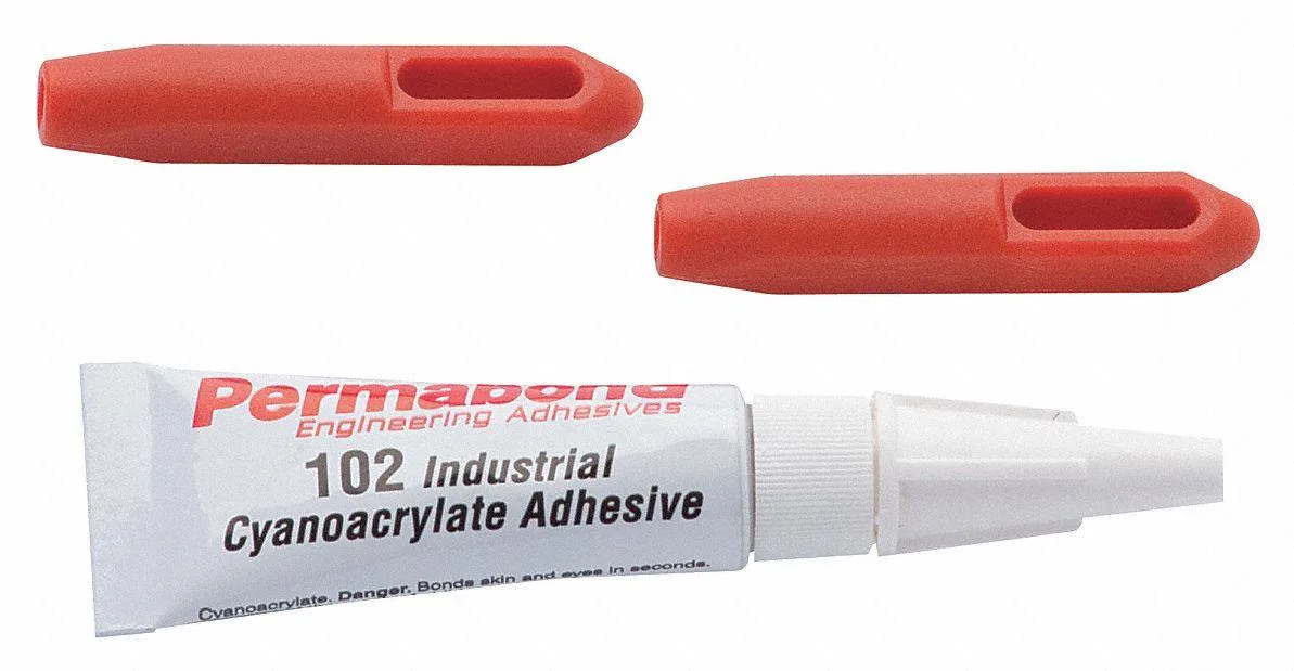 Small plastic kit with two eyelets and adhesive tube