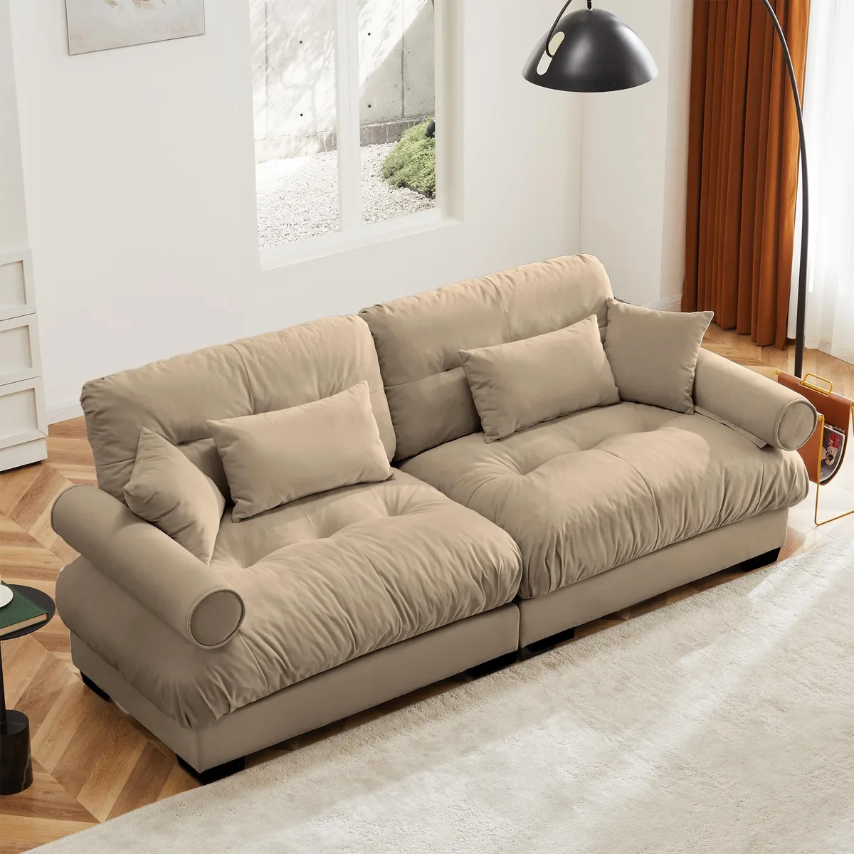 Camel velvet two-seater sofa with bolstered armrests and accent pillows