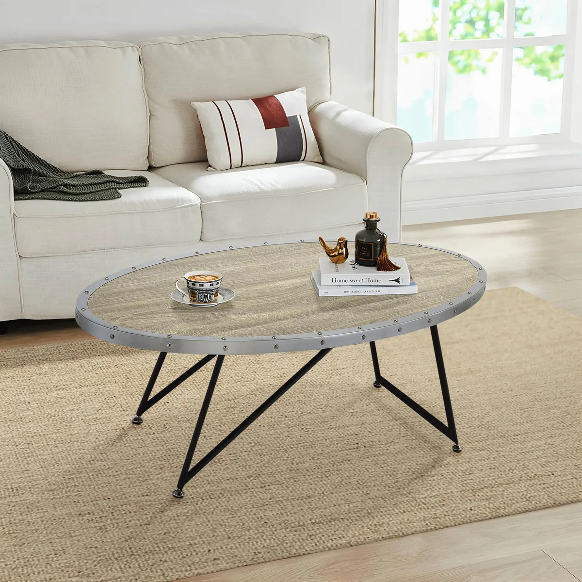 Oval coffee table with weathered grey oak top and black asymmetrical metal legs