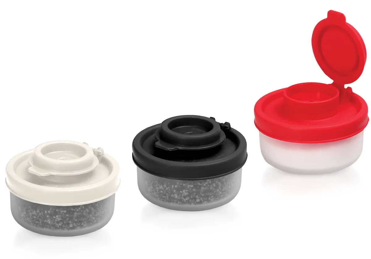 Three clear cylindrical plastic shakers with red black white lids