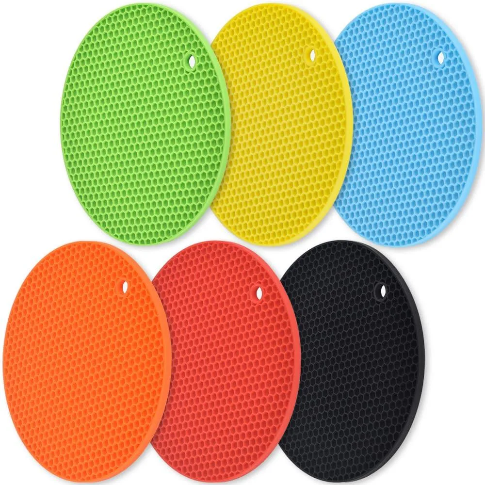 Six round silicone trivet mats in assorted colours, each 18 cm diameter with honeycomb texture and hanging hole