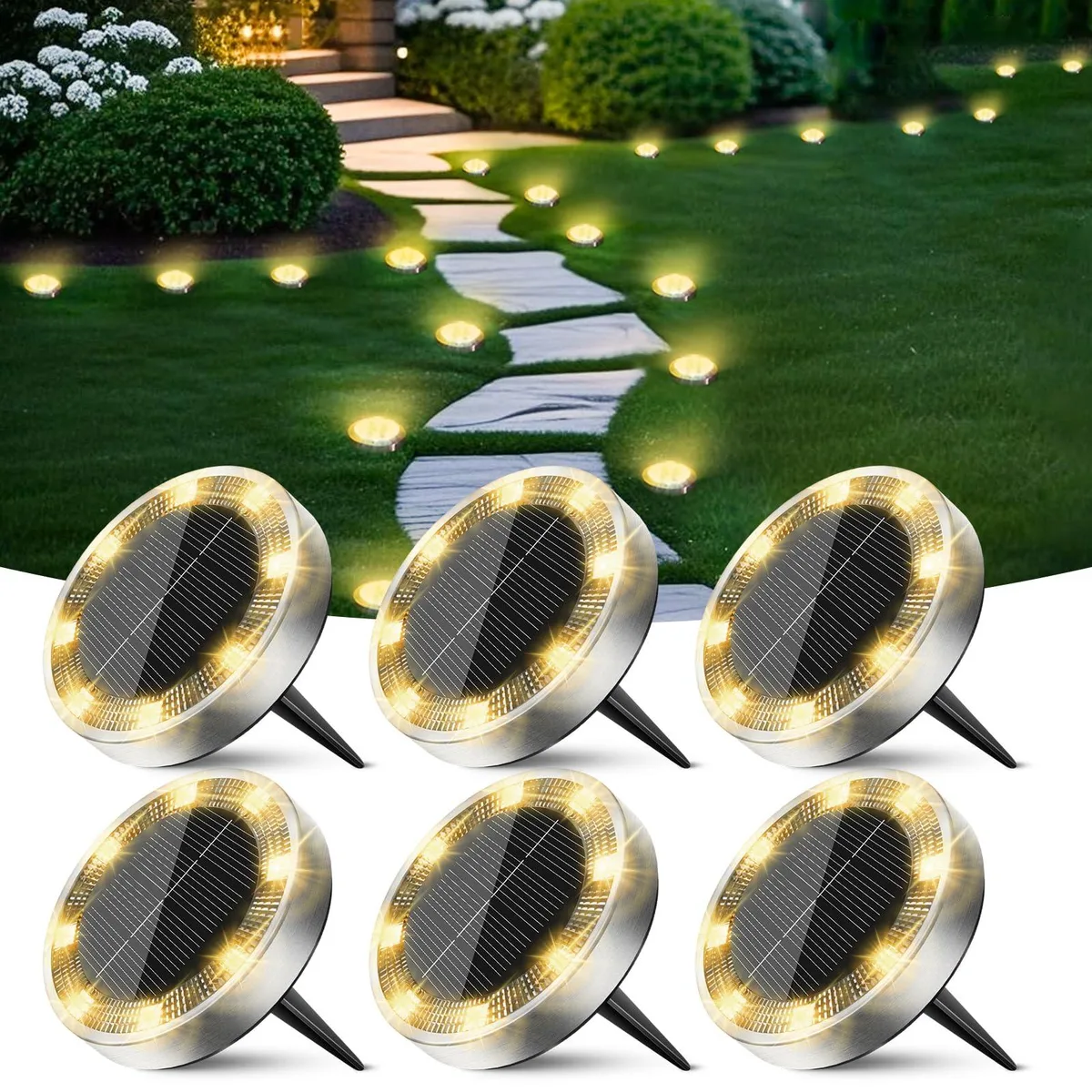 Six flat white plastic solar discs with ground spikes arranged on dark soil