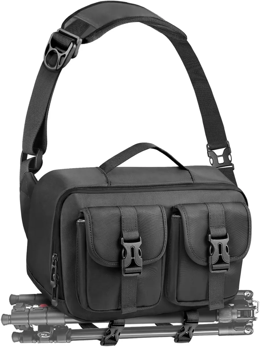 Black sling camera bag with bottom tripod strap, padded adjustable shoulder strap, front and back zip pockets