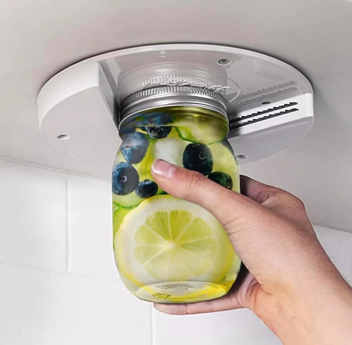 White plastic under-cabinet jar opener with stainless steel grip teeth, 7.2 inches wide