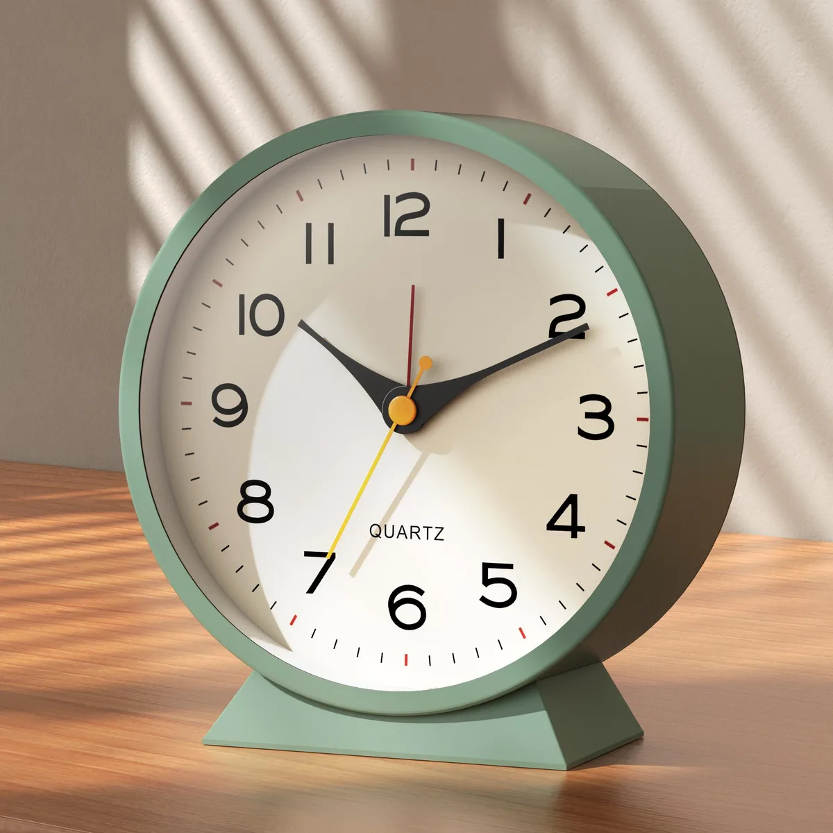 Small green retro analog alarm clock on metal frame