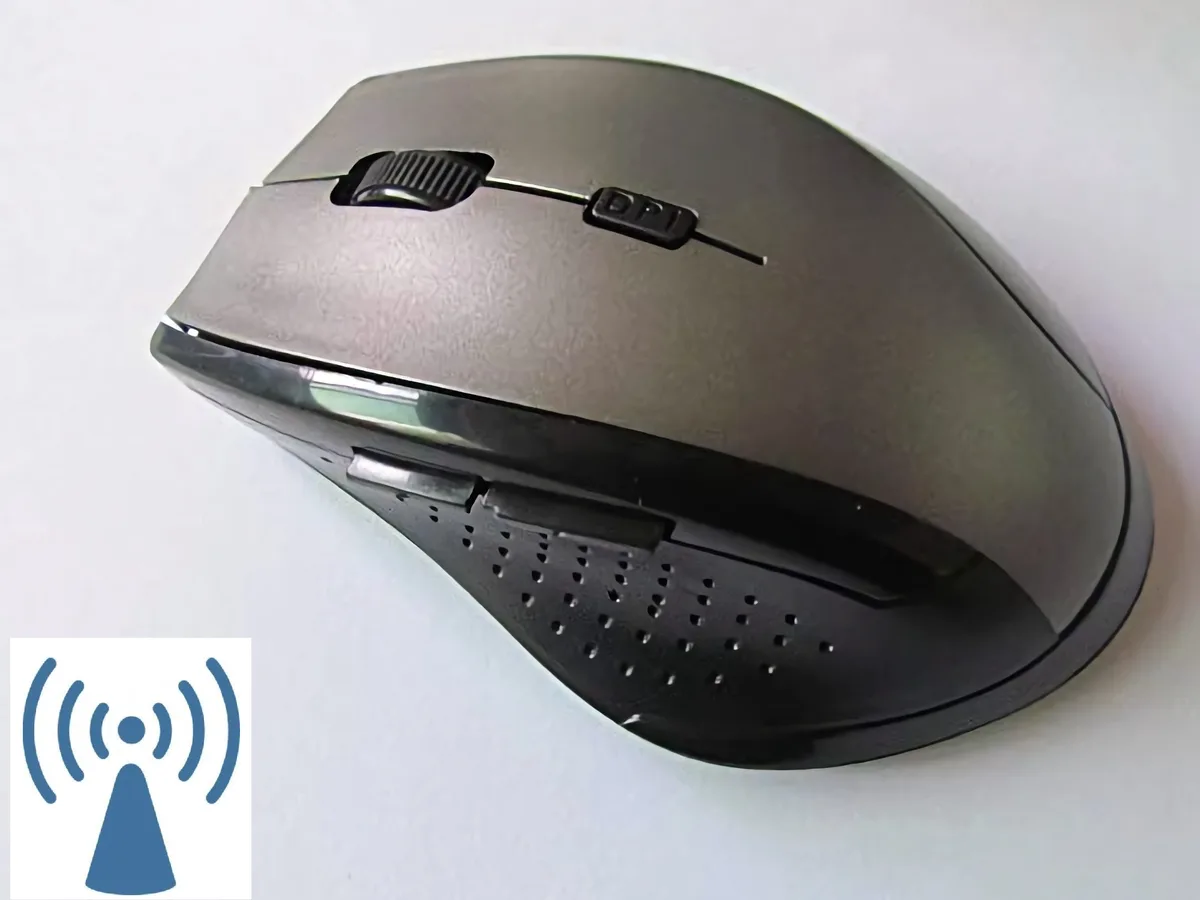 Compact wireless gaming mouse in matte black and grey with contoured right-hand shape, thumb grip, six buttons and a small USB receiver