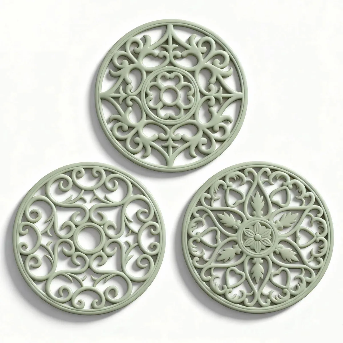 Three round sage-green silicone trivets, 7.75 in diameter, .25 in thick, with carved patterns and hanging holes