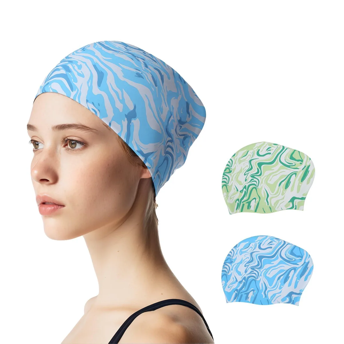 Two blue silicone swim caps with marble pattern, flat on surface