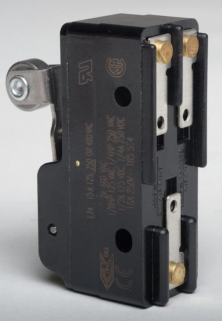 Small rectangular switch with silver lever and roller actuator, solder lug terminals, compact industrial component