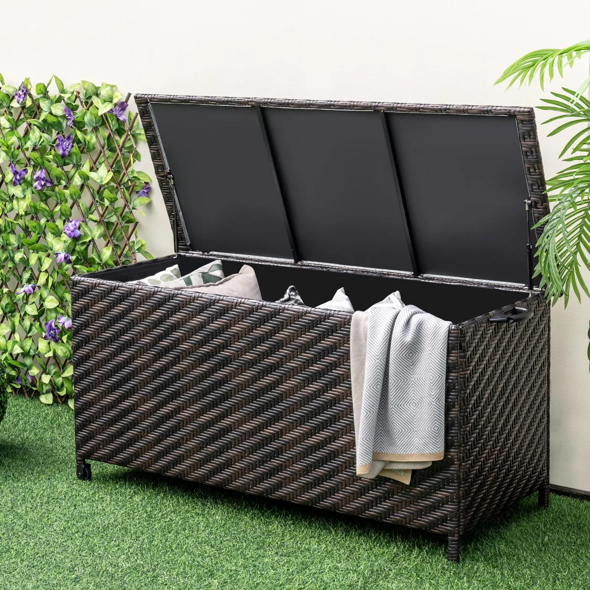Brown rectangular outdoor storage box with woven rattan texture, removable liner and four wheels