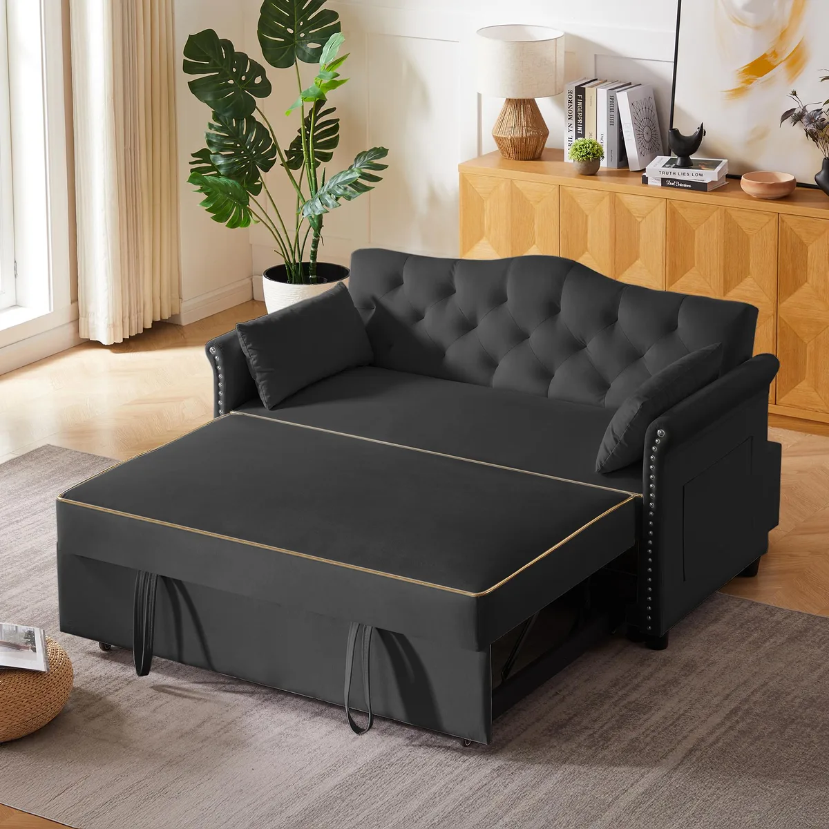Black velvet sleeper sofa with tufted back, nailhead trim armrests, and plastic legs