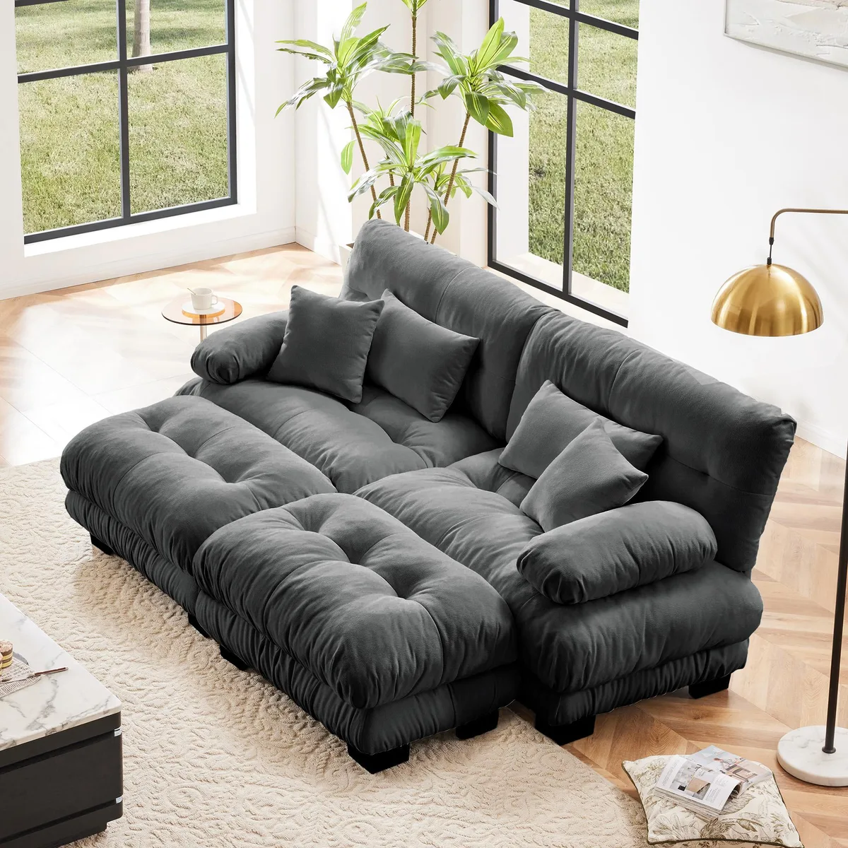 Gray chenille two-seater sleeper sofa with wide bolster arms and two matching ottomans