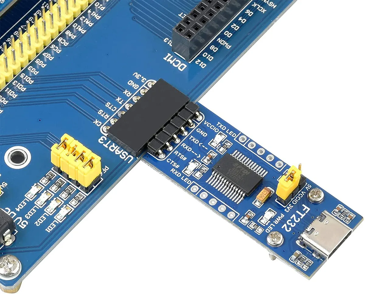 Small green circuit board with USB-C connector, pin headers, three LEDs and jumper block