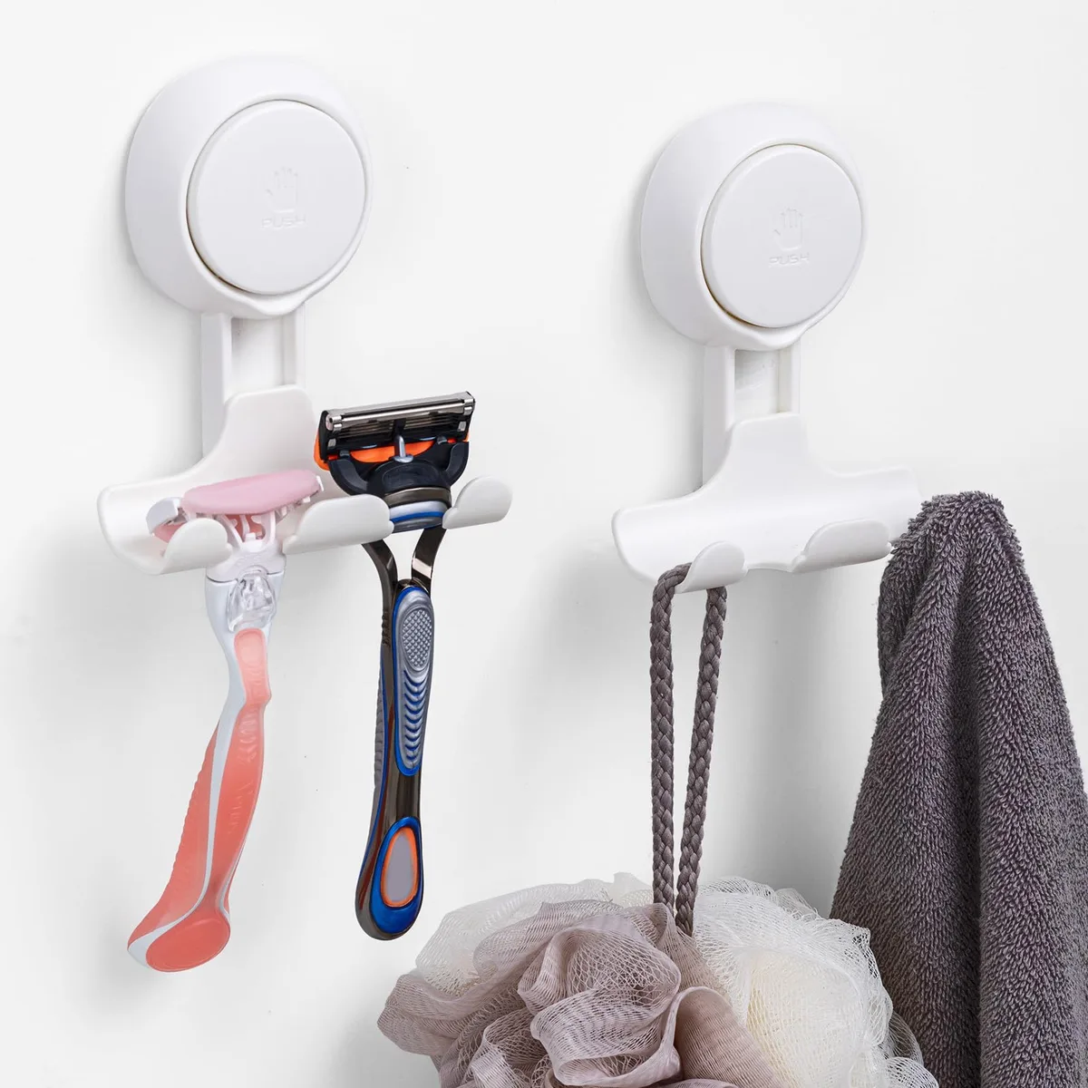 Two white plastic suction hooks with push levers and drainage holes