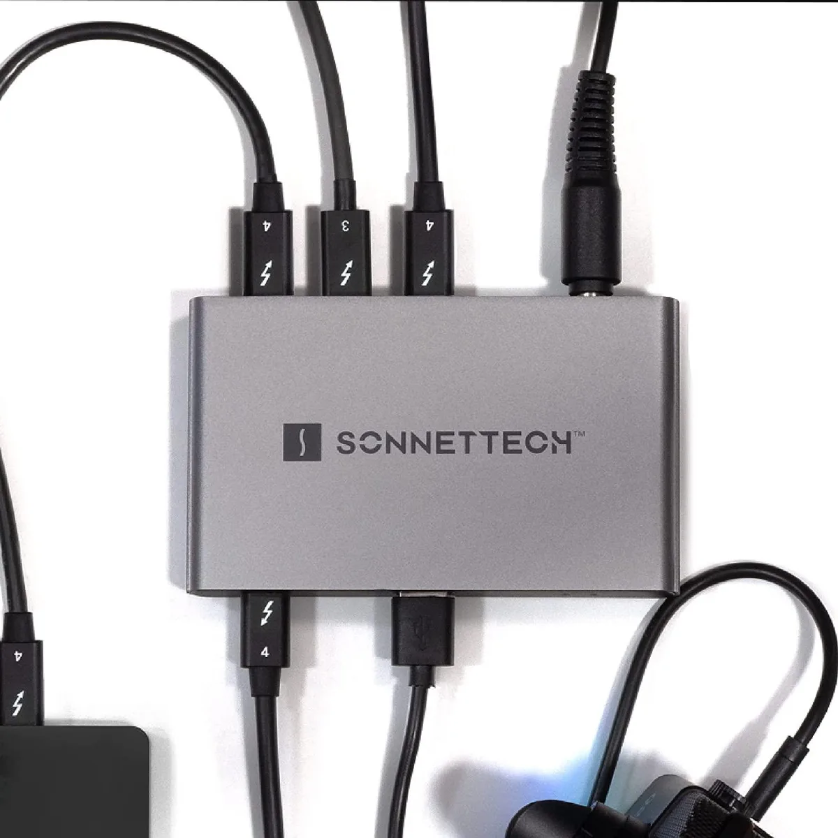 Compact silver hub with four Thunderbolt ports and one USB-A port