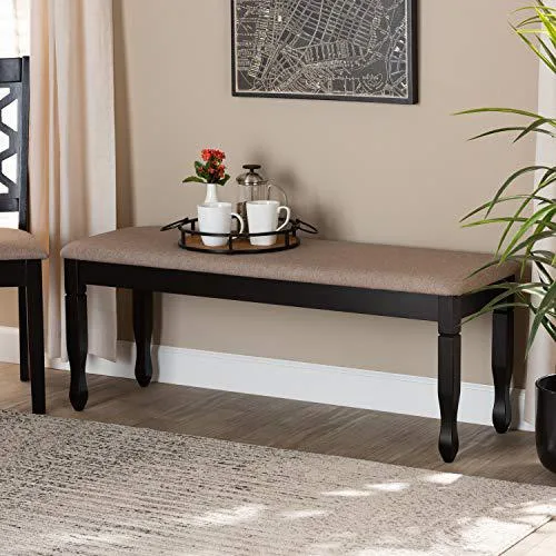 Dark brown wooden dining bench with sand fabric upholstered cushion and spade feet