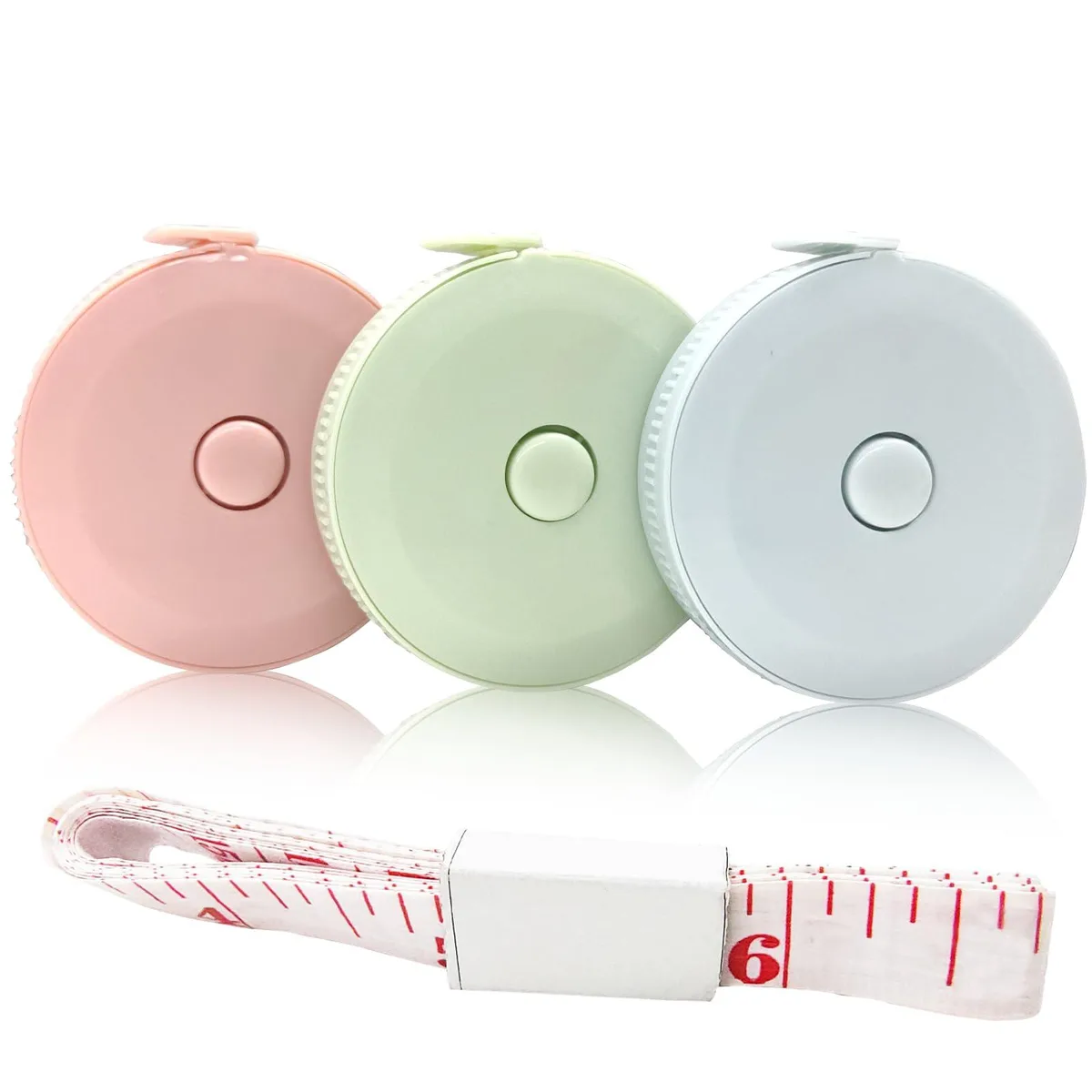 Four retractable fabric tape measures in pink green blue and folded white each 150cm 60in with dual scale markings
