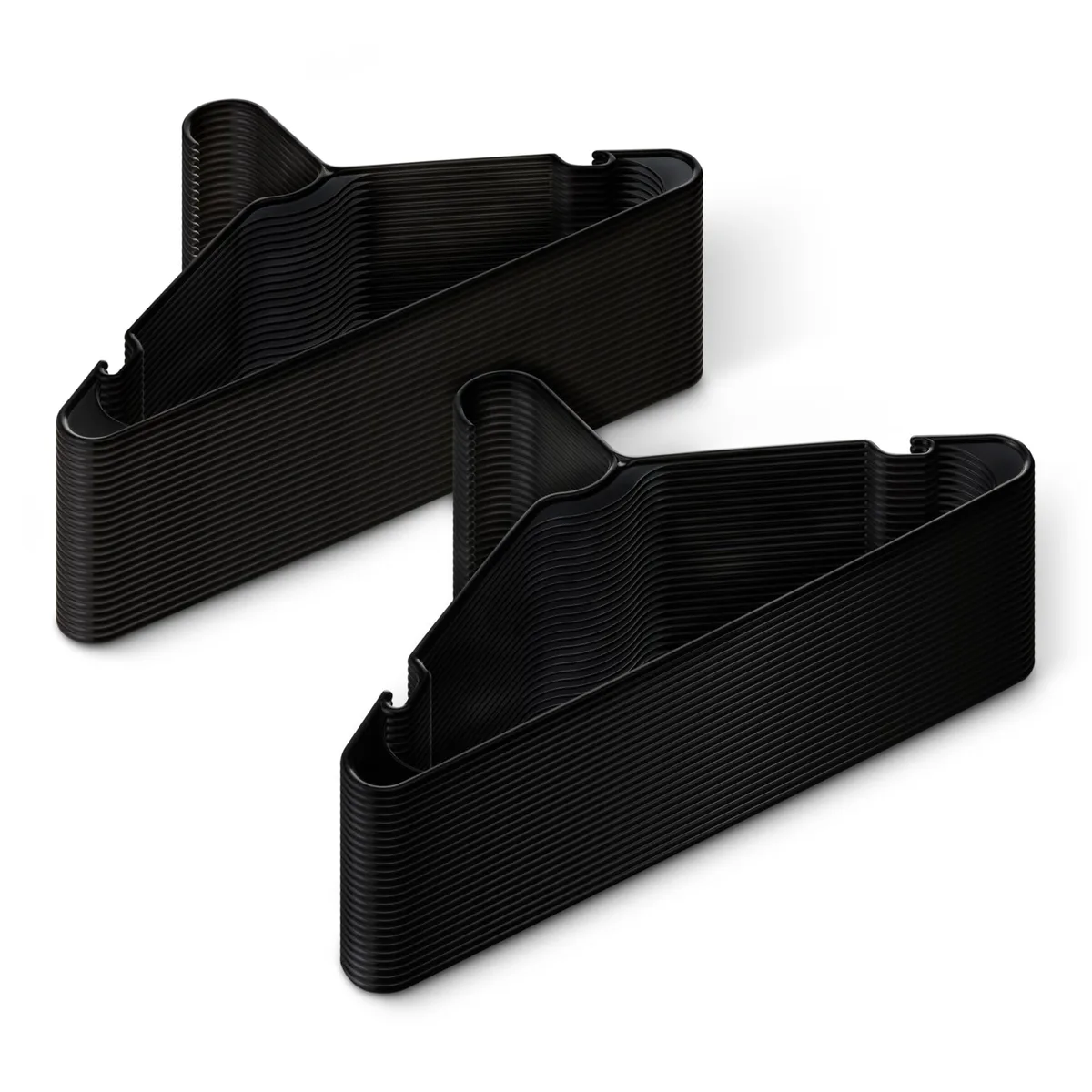Fifty black plastic clothes hangers with curved hooks stacked together
