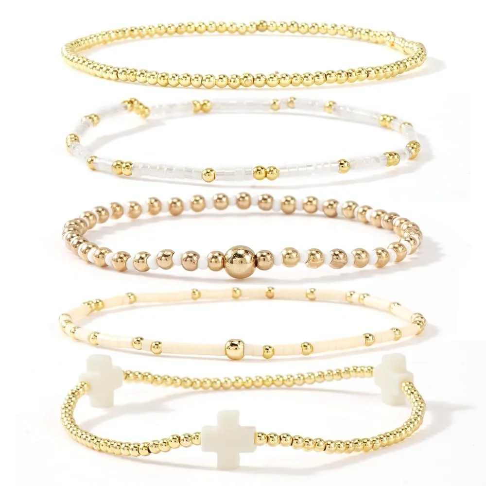 Gold beaded stretch bracelets with a white cross charm, stackable elastic design