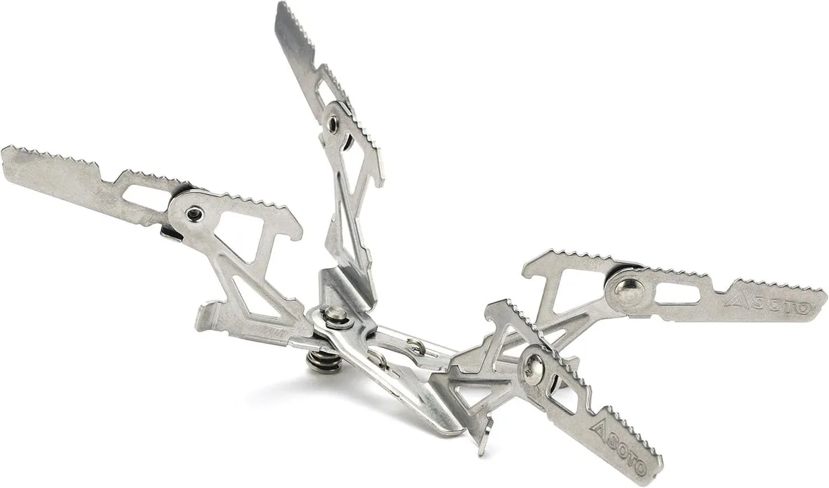 Folding stainless steel stove stand with four curved legs, shown open and attached to a compact canister stove base