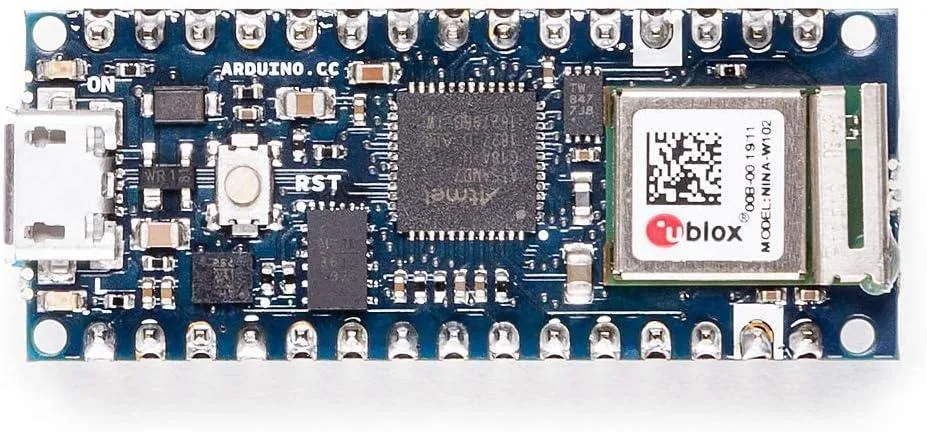 Small green circuit board with two rows of gold pin headers along its long edges, a silver metal Wi-Fi module near one corner