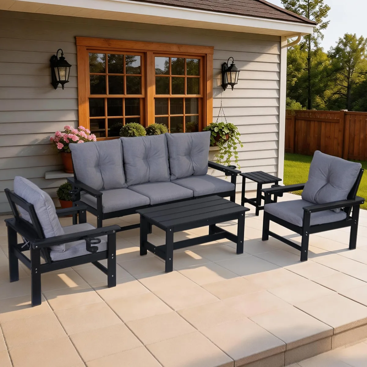 Black HDPE patio furniture set with seven modular pieces and thick cotton cushions arranged on outdoor surface