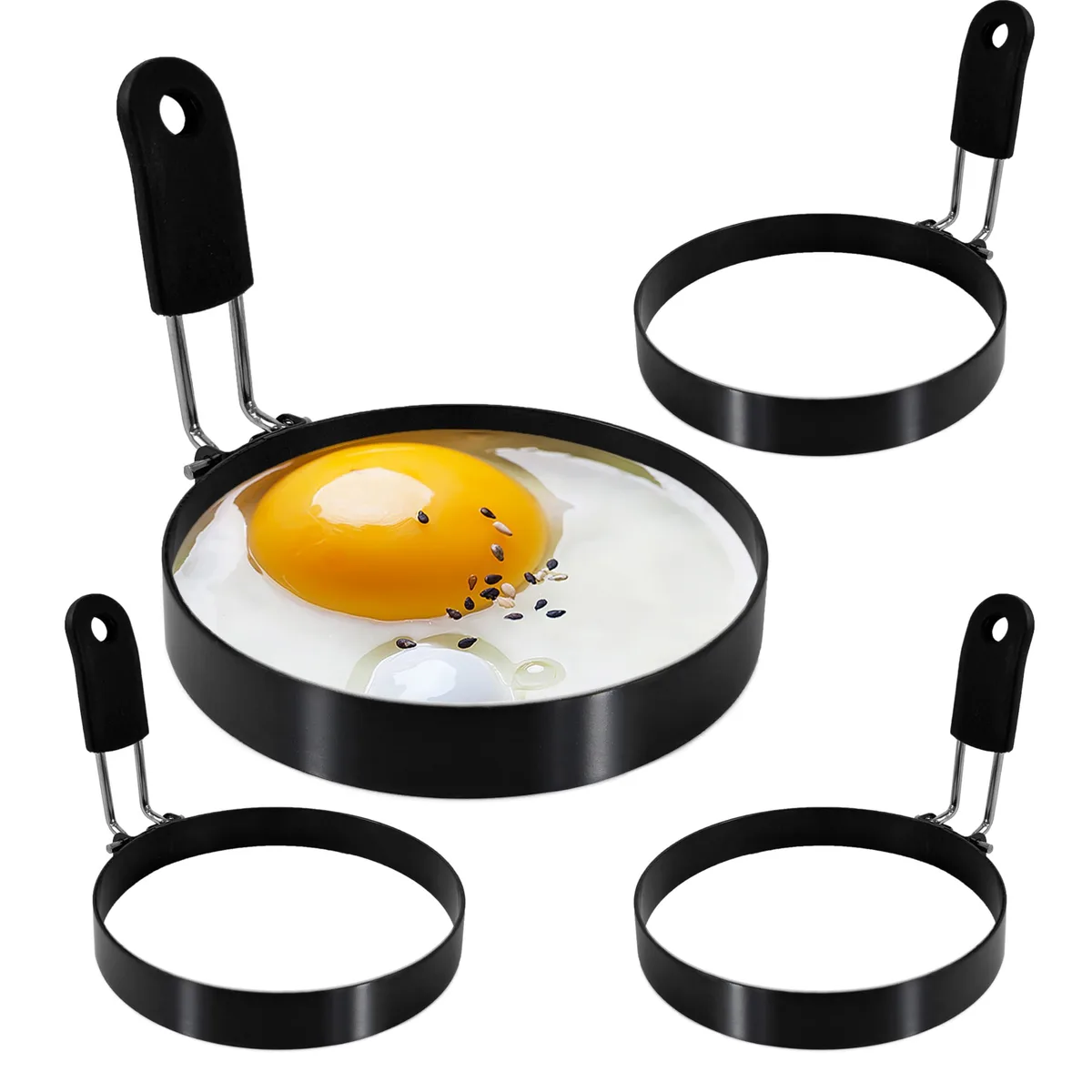 Four stainless steel egg rings with black silicone handles