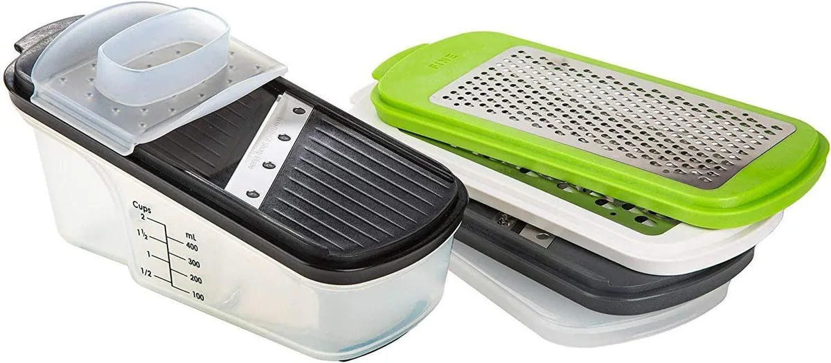 A seven-piece food processor set with interchangeable slicing and grating panels, a hand guard, and a measuring container with cover