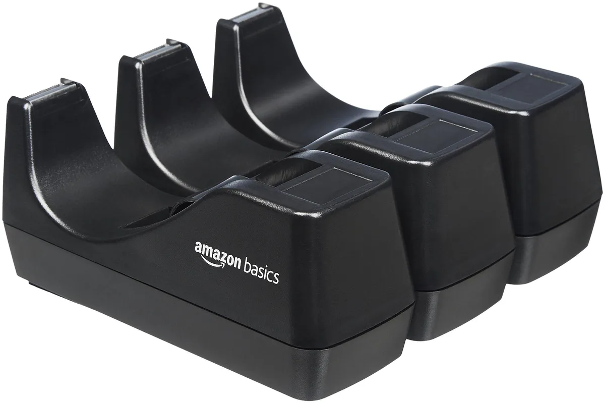 Three black plastic tape dispensers on a desk
