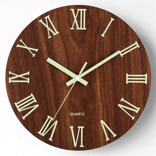 Round black and white wall clock with glow-in-the-dark numerals and star pattern, plastic frame, glass cover